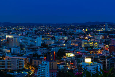 High angle view of illuminated city against clear sky at dusk
