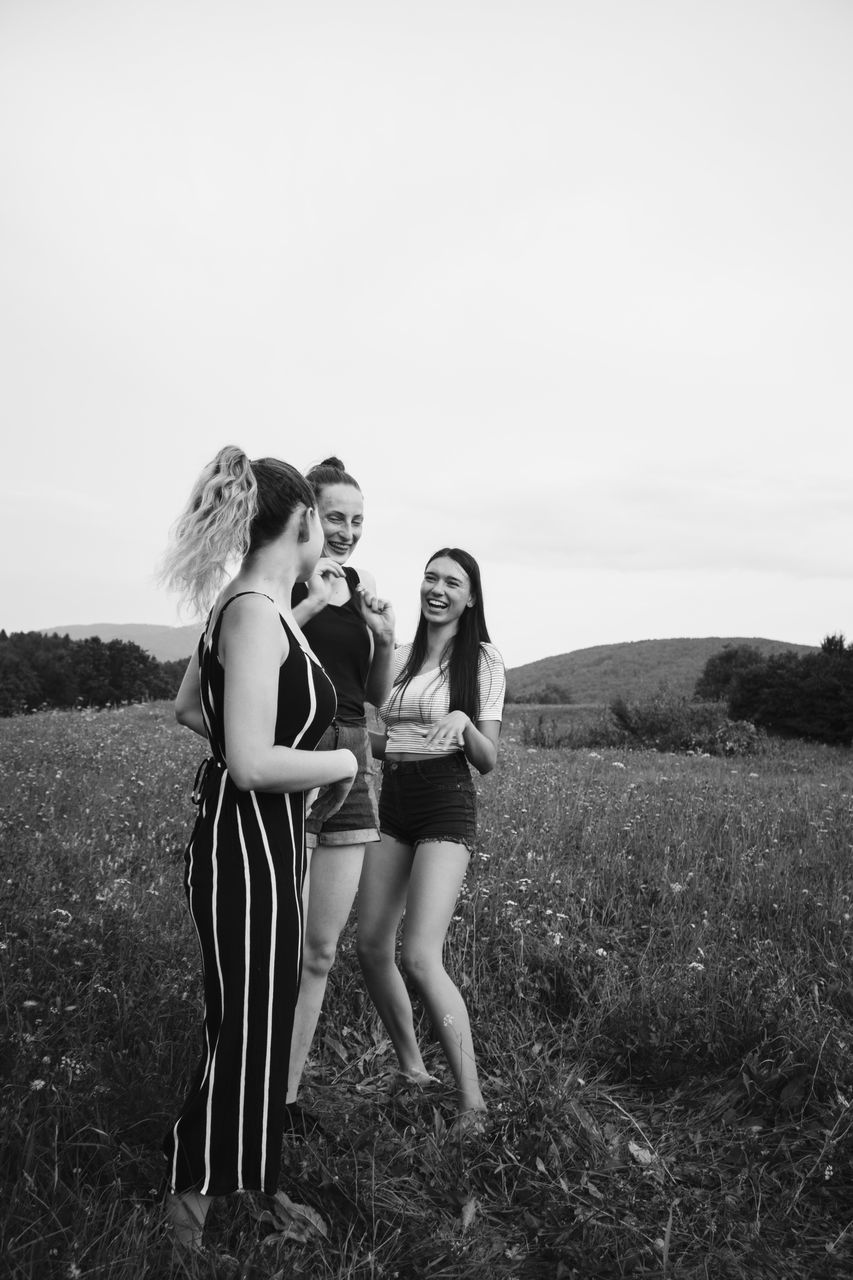 sky, leisure activity, field, real people, young women, plant, lifestyles, standing, land, young adult, togetherness, women, people, casual clothing, nature, grass, adult, copy space, bonding, fashion, outdoors, teenager