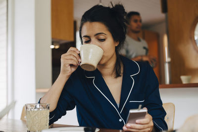 Portrait of young woman drinking coffee