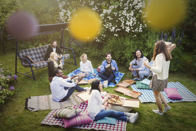 High angle view of friends having snacks during summer party at yard