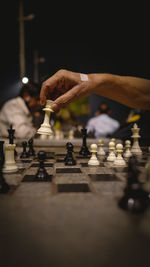 Side view of man playing on chess board