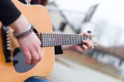 Midsection of man playing guitar