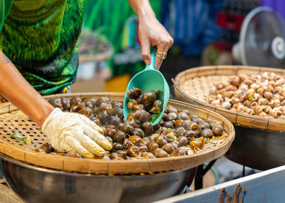 Cropped hand of man preparing food for sale