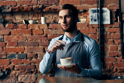 Portrait of young man drinking coffee