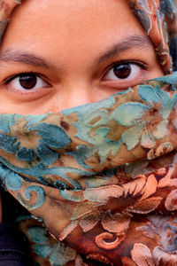 Close-up portrait of woman face covered with scarf