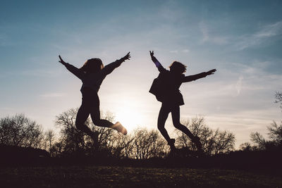 Full length of silhouette woman jumping at sunset