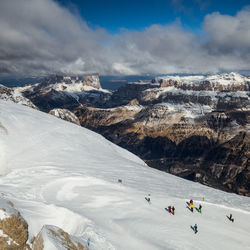Group of people on snowcapped mountain against sky