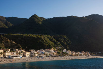 Scenic view of sea and mountains against clear sky