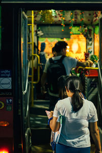 Rear view of people standing on train