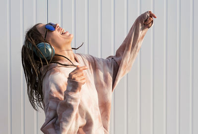 Dreadlock woman listening to music in headphones.