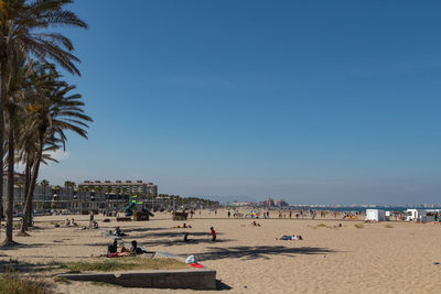 People on beach against clear sky