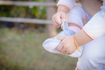 Low section of baby holding booties