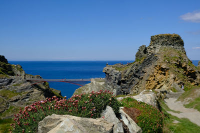 Rock formations by sea against clear sky