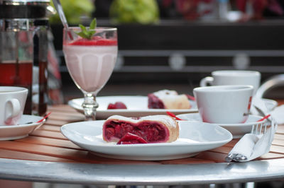 Delicious dessert cherry strudel on a table in street cafe with fruit milkshake