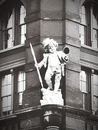 Low angle view of statue against building in city