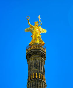 Low angle view of statue of liberty against blue sky