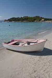 Boat moored on beach against sky