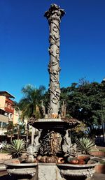Statue of palm trees against clear blue sky