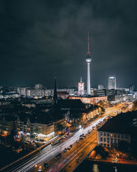 Illuminated buildings in city against sky at night