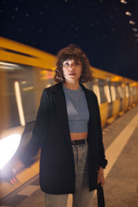 Portrait of young woman standing in city