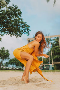 Portrait of young woman dancing on the beach 