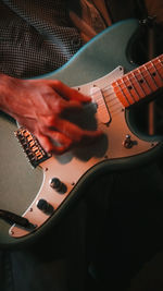 Midsection of man playing electric guitar