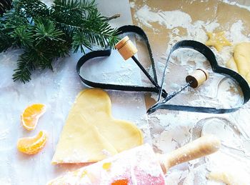 High angle view of heart shape pastry cutter and dough