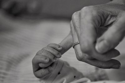 Cropped image of parent holding hand of baby