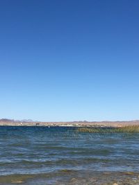 Scenic view of sea against clear blue sky