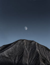 Low angle view of mountain against clear sky at dusk