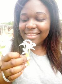 Close-up of smiling young woman with flowers in hair