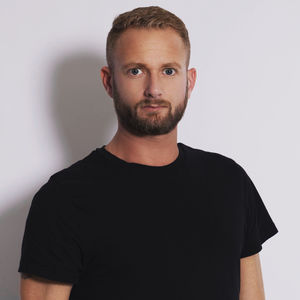 Portrait of young man standing against white background