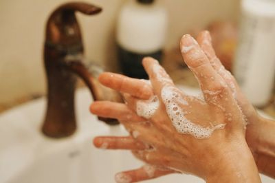 Close-up of woman washing hands in sink at bathroom