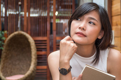 Close-up of thoughtful beautiful woman looking away while siting in cafe