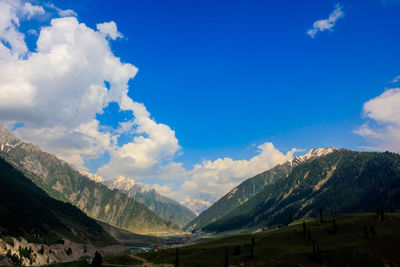 Scenic view of landscape and mountains against blue sky