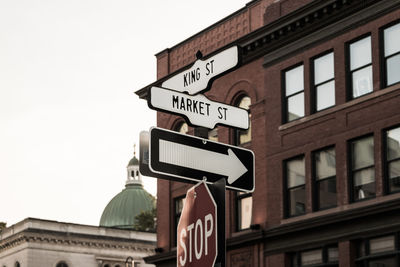 Low angle view of road sign against clear sky