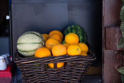 Oranges and watermelons in wicker basket