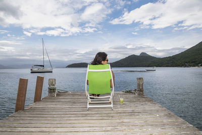 Woman relaxing on pier on the tropical island of ilha grande