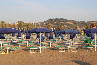 Chairs on beach against sky