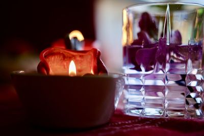 Close-up of burning candles on glass