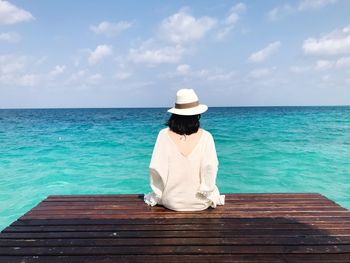 Rear view of woman looking at sea against sky