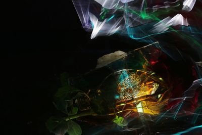 Close-up of illuminated lighting equipment against black background