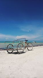 Pedicab at beach against blue sky