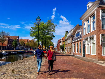 People walking on building against blue sky