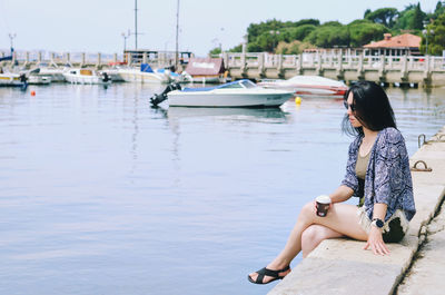 Side view of young woman sitting in water