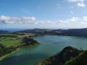 Scenic view of sea and mountains against sky