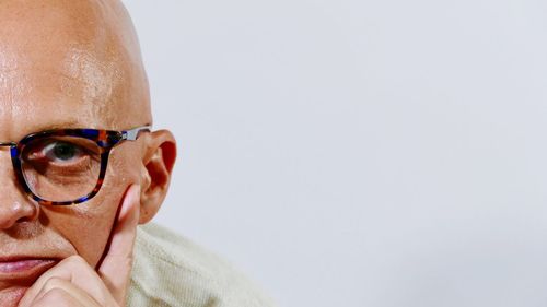 Portrait of man wearing sunglasses against white background