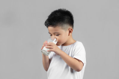 Boy standing against white background