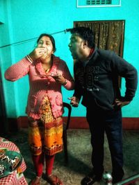 Full length of happy friends standing at home