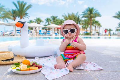 Portrait of young woman wearing sunglasses on table